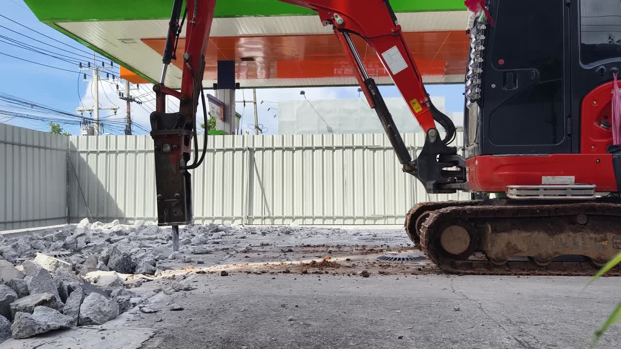 trabajos de demolición con mini excavadora y martillo aerodinámico en una gasolinera