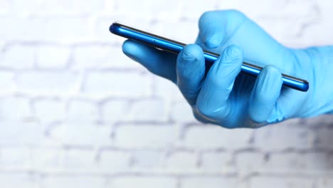 en guantes médicos usando un teléfono inteligente