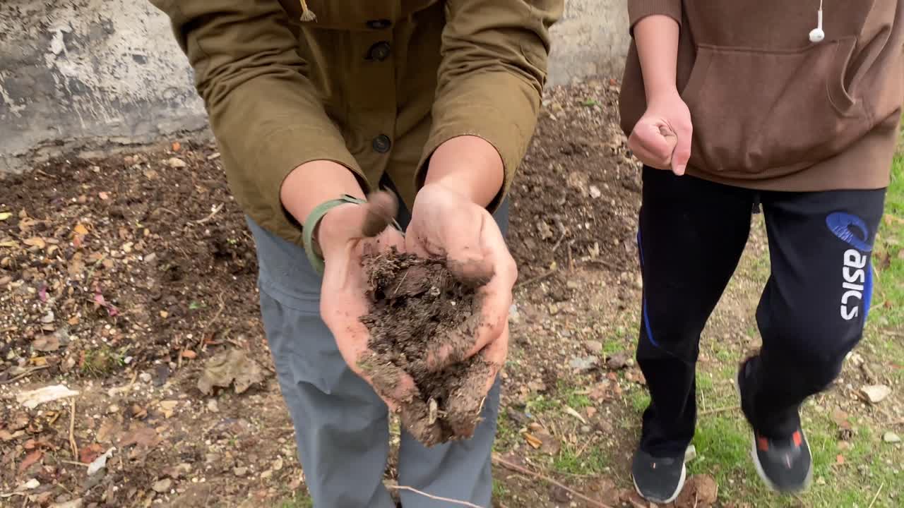 mujer analizando compost basura húmeda en la tierra después de la descomposición basura desechada hacer agricultura biológica natural fertilizado a partir de cáscaras de frutas restos de alimentos y basura descartable en irán teherán