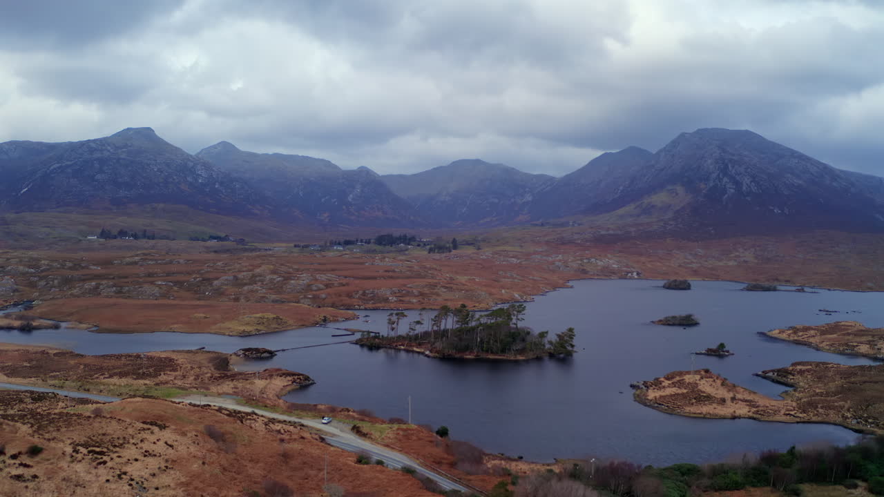 Aerial tracking shot of Pine Island and the Twelve Bens at twilight, showcasing Connemara’s dramatic beauty, Galway, Ireland