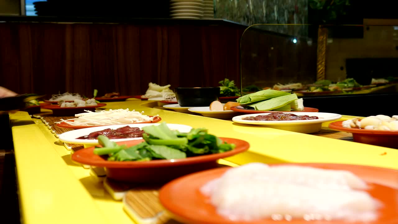 platos de comida fresca en el cinturón en un restaurante japonés