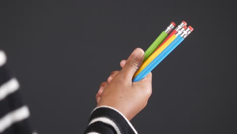 la mano con lápices de colores