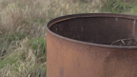 rusty oil drum abandoned in a field isolated