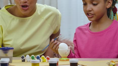 madre e hija pintando huevos de pascua