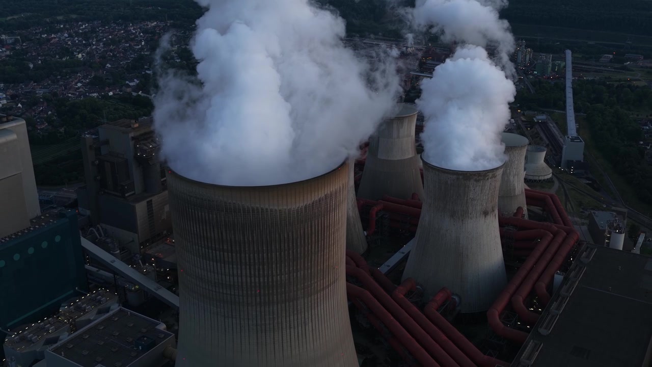 Aerial view of a massive lignite-fired power plant with large cooling towers, showing fossil fuel electricity generation, heavy industry and energy infrastructure.