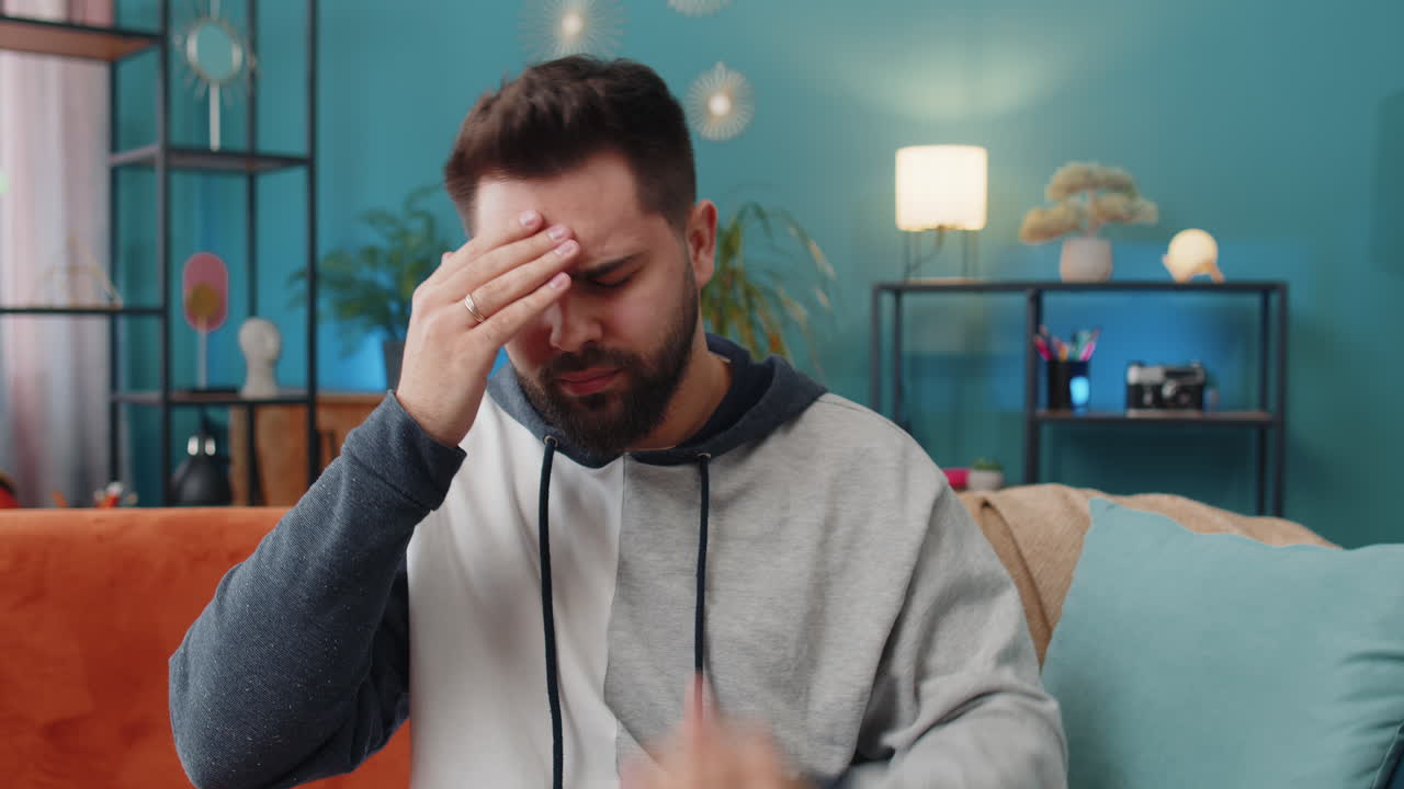 Displeased caucasian man rubbing temples to cure headache problem suffering from migraine stress