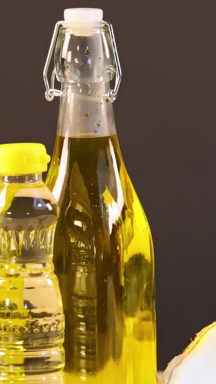 Bottiglie di olio, semi e frutta secca disposte su una superficie di legno con illuminazione calda