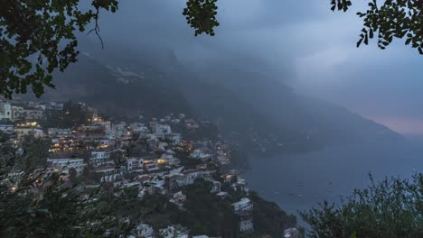 time lapse monsoon rain approaches the coast of positano, italy, skillfully framed by trees