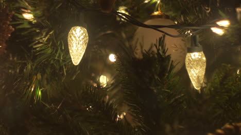 una diapositiva di primo piano sulle luci e gli ornamenti dell'albero di natale, bokeh, messa a fuoco selettiva, macro, da sinistra a destra