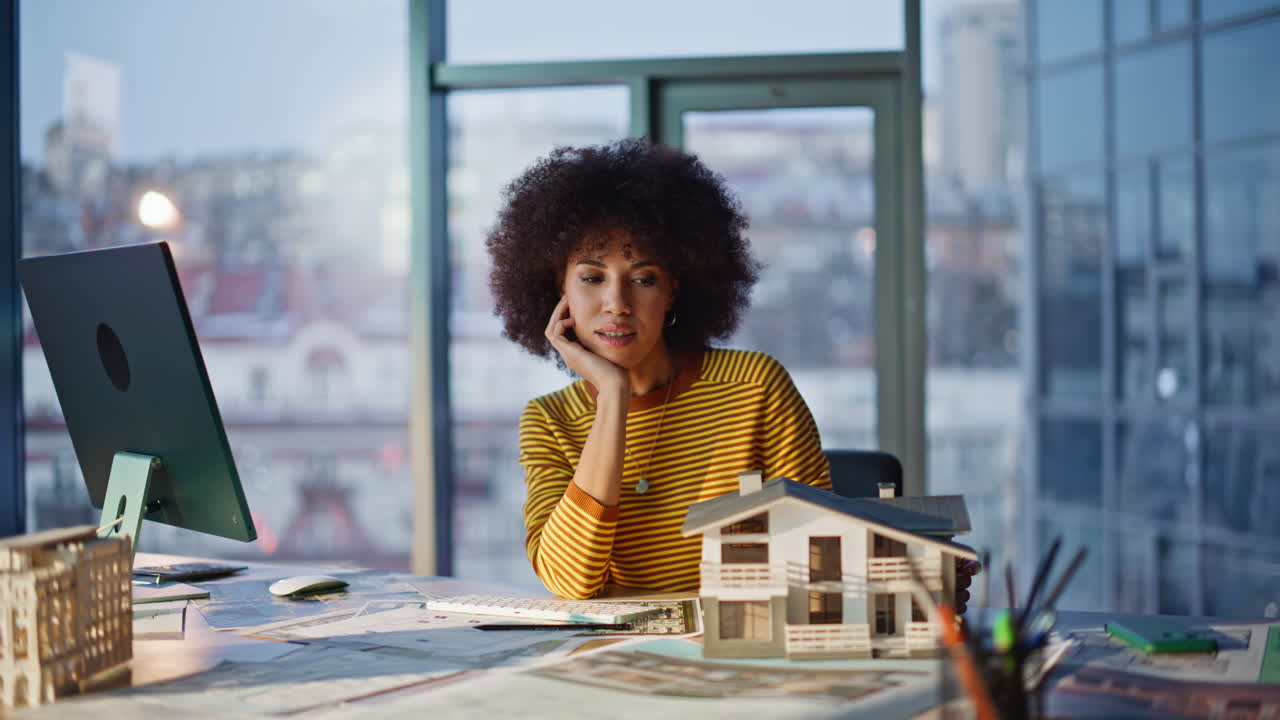 Building designer satisfied model residential house at office. Smiling woman
