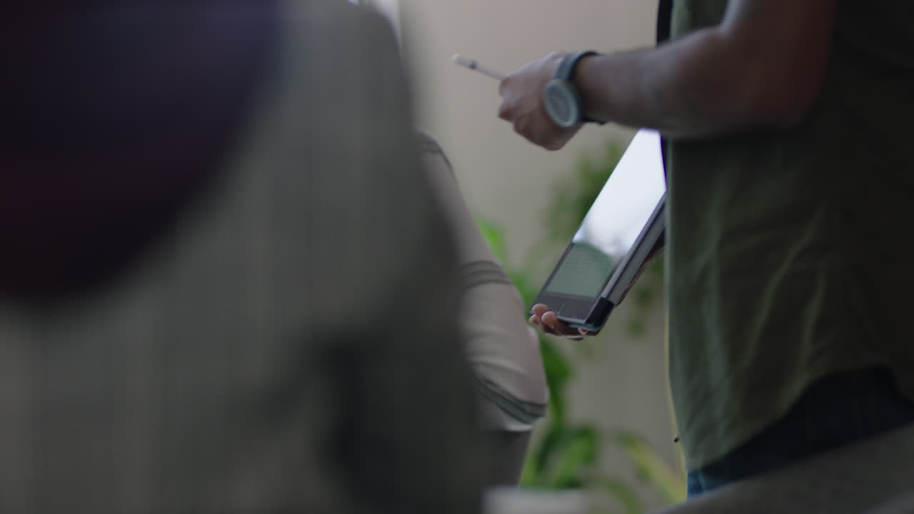 close up young indian businessman using digital tablet computer presenting financial graph data showing colleagues in office presentation diverse team collaborating brainstorming strategy