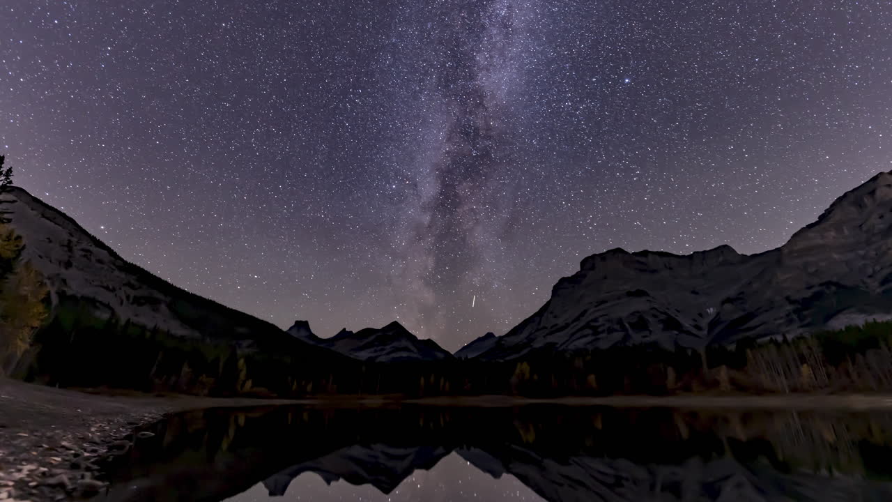 The Milky Way passes across the Canadian Rockies along the calm waters of Wedge Pond, near Kananaskis, Alberta