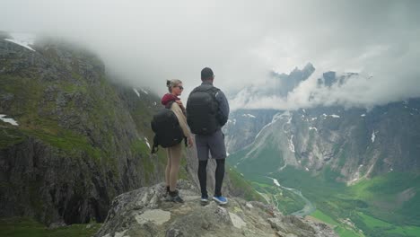 dos excursionistas en noruega con una impresionante vista de trollveggen y el valle de abajo