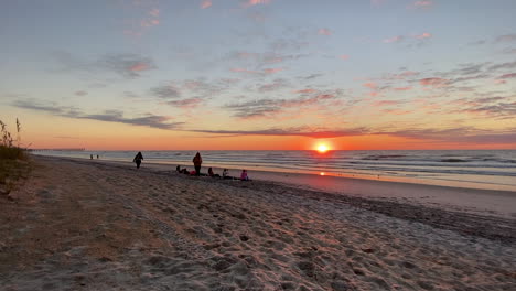 turista en la costa arenosa con un hermoso cielo de puesta de sol sobre el paisaje marino