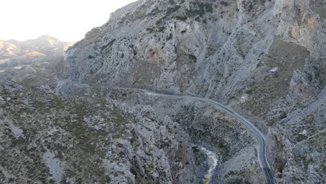 Vista-Aérea-De-La-Carretera-De-Montaña-En-Grecia-Entre-Empinadas-Laderas-Rocosas