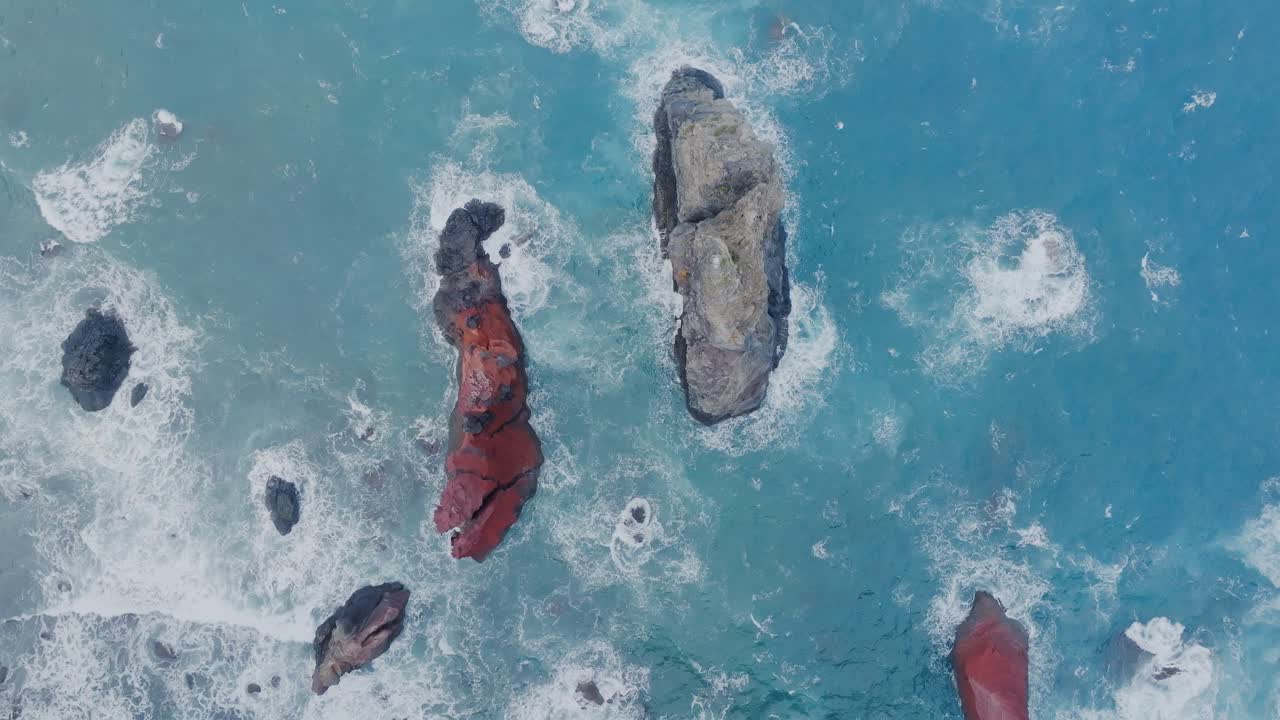 las olas azules del océano golpean las rocas cerca de la isla