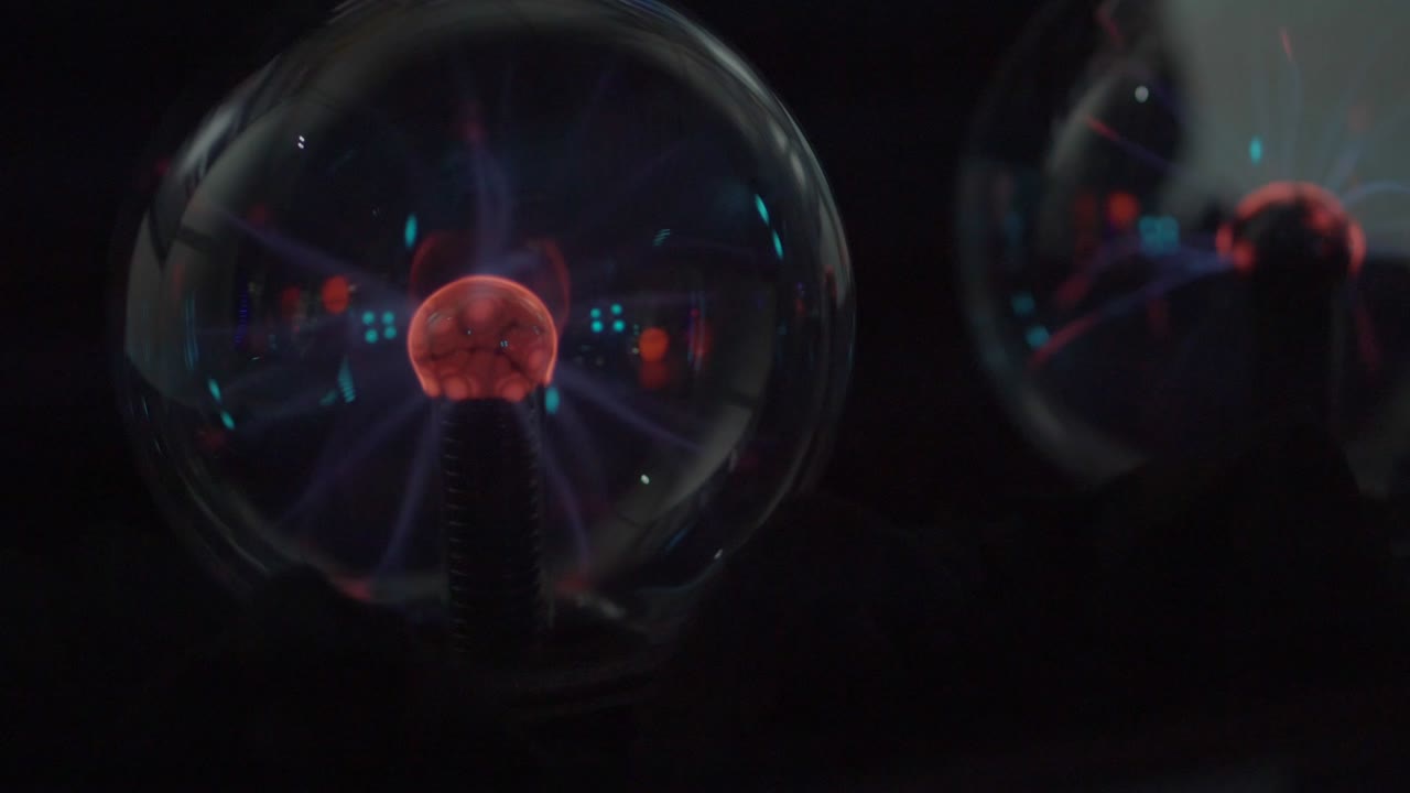 자기장과 전기선이 있는 두 개의 유리 공이 어 속에 서 있습니다.