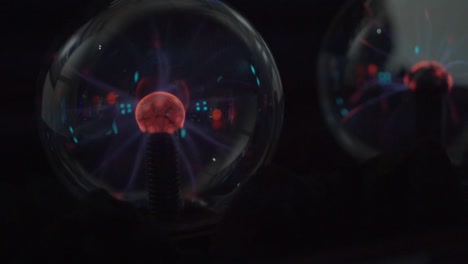 dos bolas de vidrio con campos magnéticos y rayos eléctricos están de pie en la oscuridad