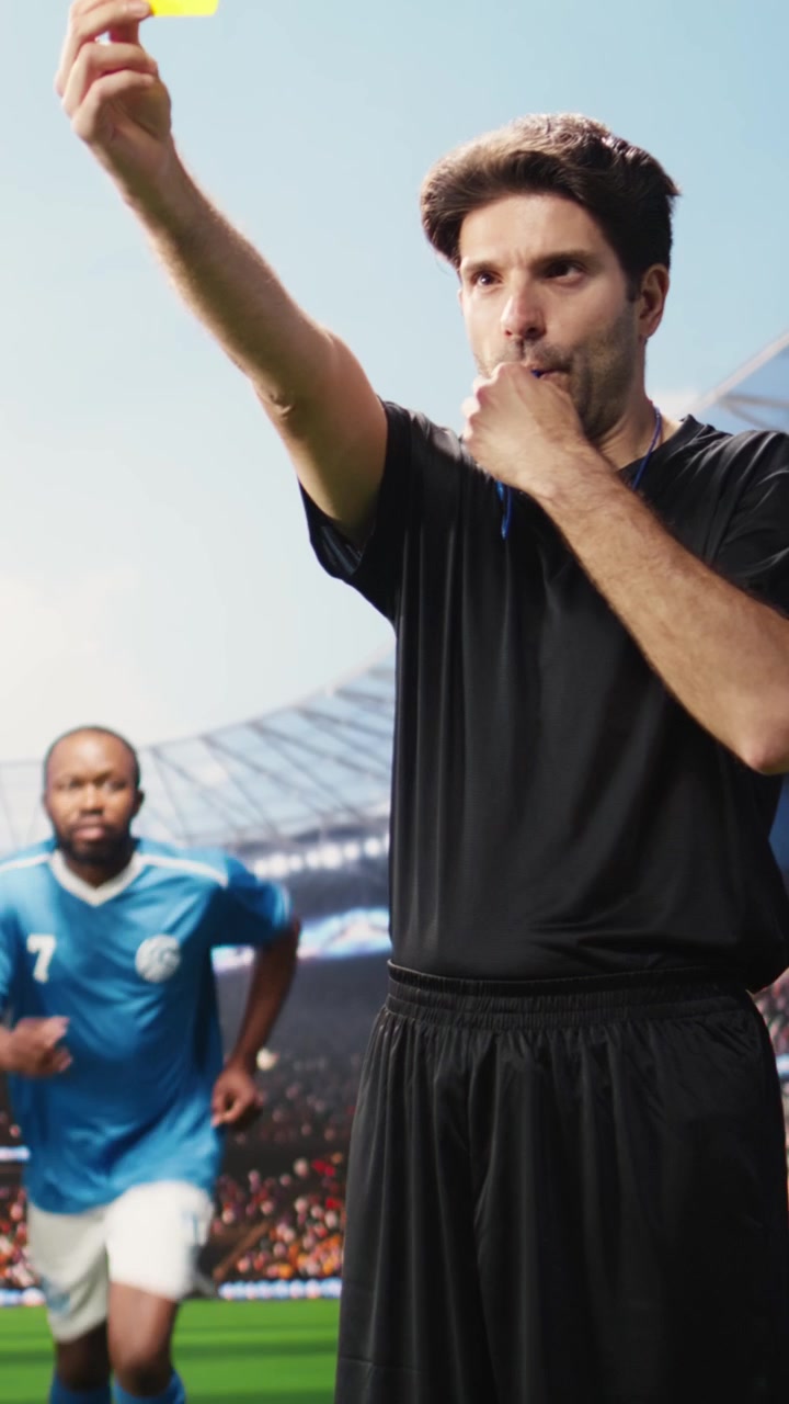 Video verticale: arbitro di calcio che ferma una discussione accesa con il cartellino giallo alzato.