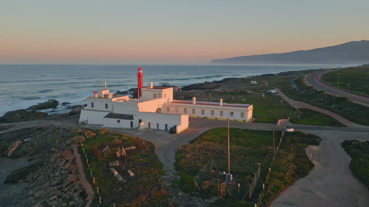 Aerial coastal beacon standing rocky seashore at summer sunset. Beautiful sky