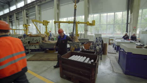 factory workers handling metal parts