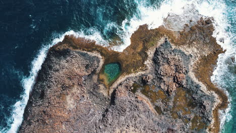 aerial of a private cove in caleta de fuste, surrounded by the ocean