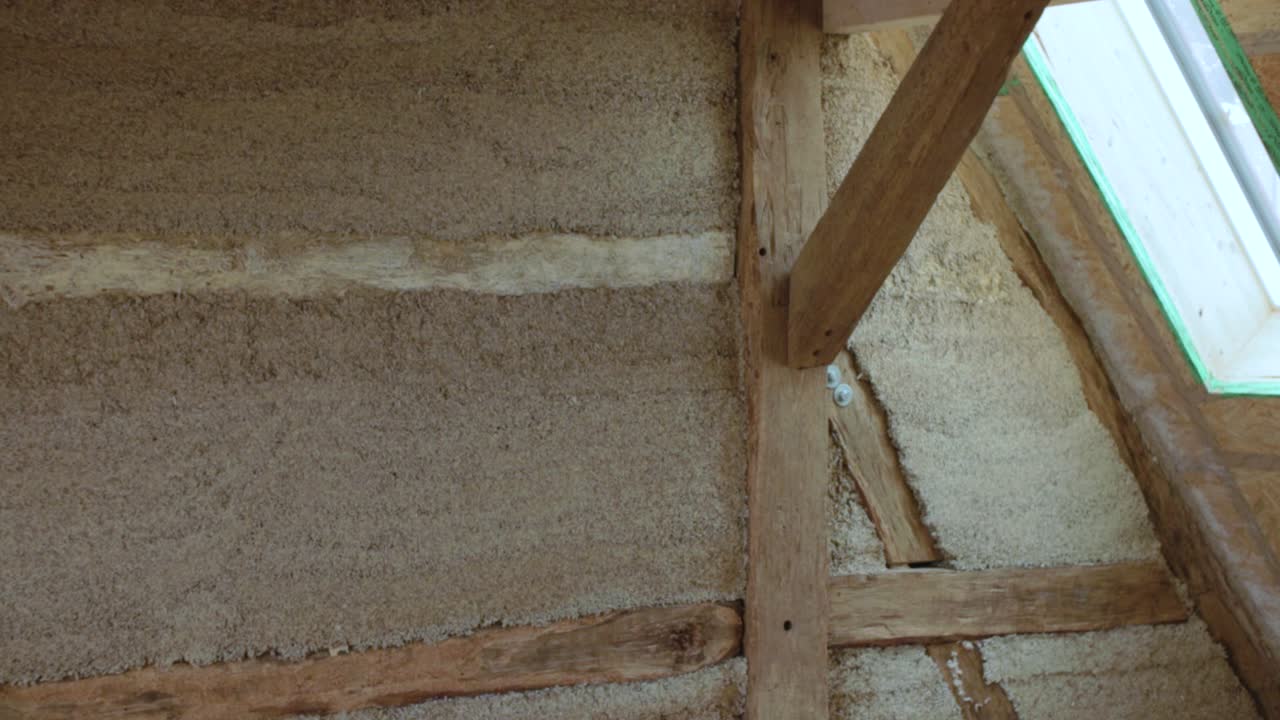 Transition sideways revealing a hempcrete wall in a timber frame inside a construction site