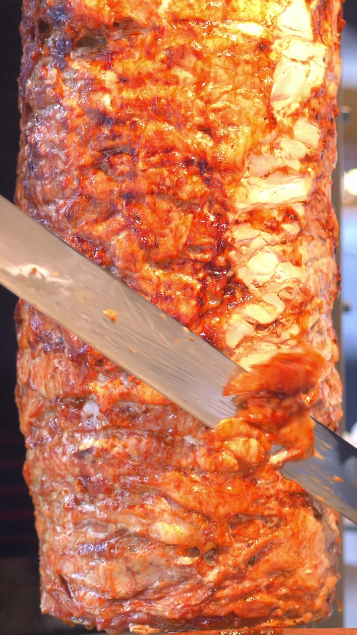 Close-up of Slicing Shawarma Meat on a Vertical Grill