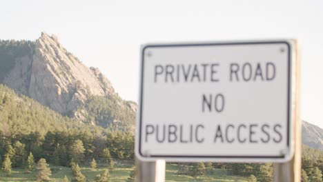 Sign-saying-Private-Road,-NO-Public-Access,-sunny-mountain-landscape-in-background,-privacy-traffic-sign