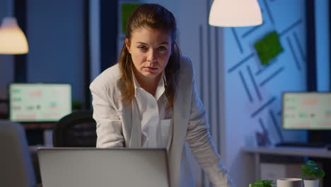 focused business woman looking at camera standing near desk