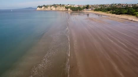 aerial view of a low tide beachfront with cliffside homes in the background, showcasing the peaceful coastal scene of son tra peninsula, da nang, vietnam
