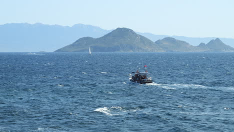 boat cruising in the blue sea near gumusluk in turkey