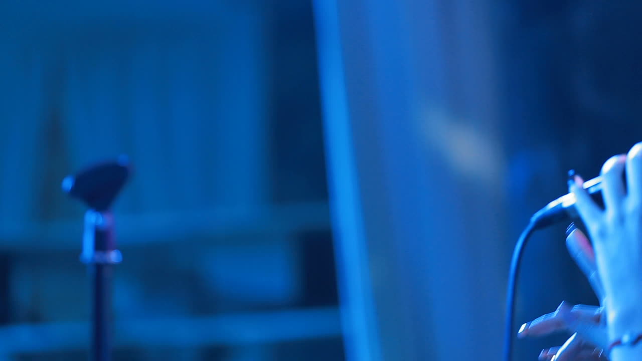 Young singer with a microphone. ?lose up portrait of attractive young singer with a microphone