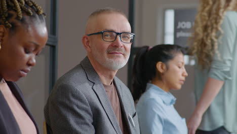 portrait of senior businessman waiting in line for job interview