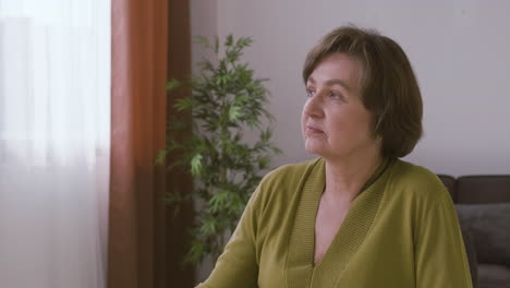 senior woman with gray hair sitting and looking at side