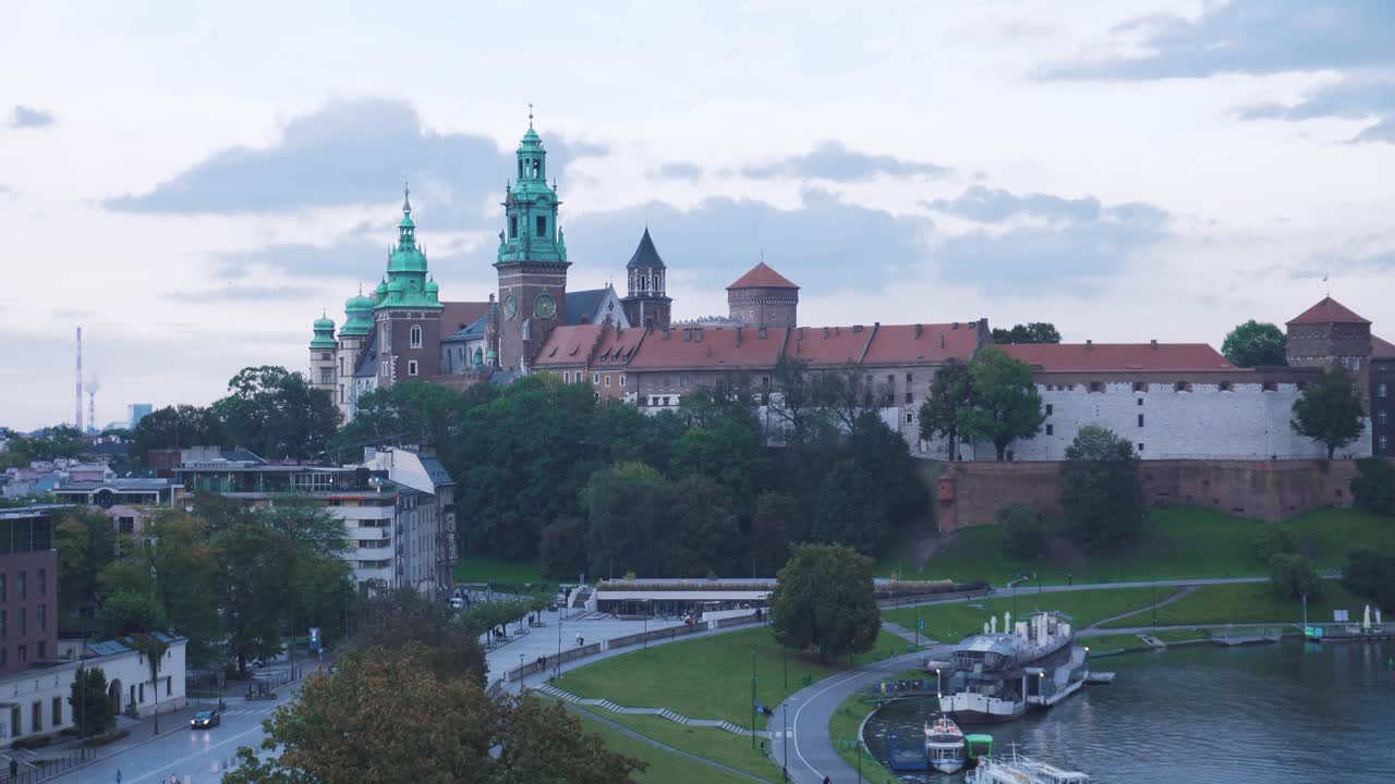 Castello di Wawel sullo sfondo con alcuni giardini e un cielo nuvoloso a Cracovia
