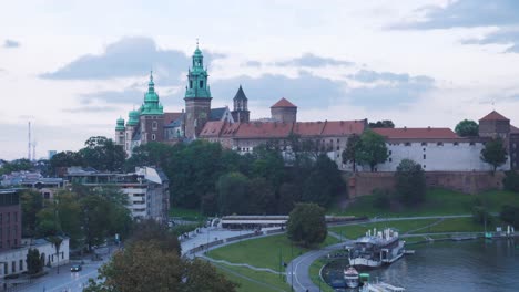 Castillo-De-Wawel-En-El-Fondo-Con-Algunos-Jardines-Y-Un-Cielo-Nublado-En-Cracovia