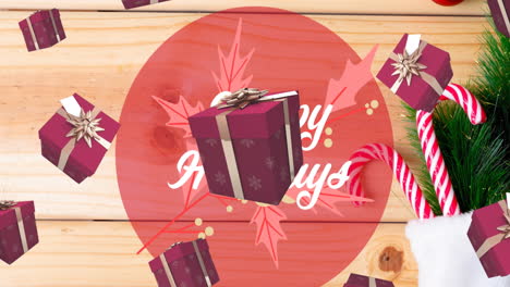 animation of happy holidays text over presents falling and christmas decoration on table