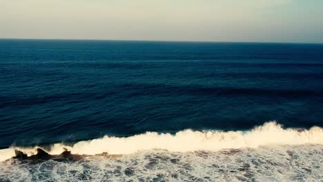 Aerial-footage-filmed-with-a-drone-overlooking-the-beach-and-sea-of-crashing-waves-with-a-deep-blue-ocean-on-the-Bluff-in-Africa-southern-hemisphere