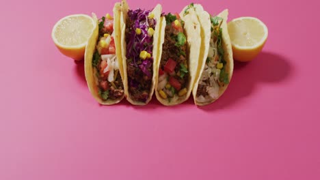 video de tacos recién preparados a bordo sobre un fondo rosado