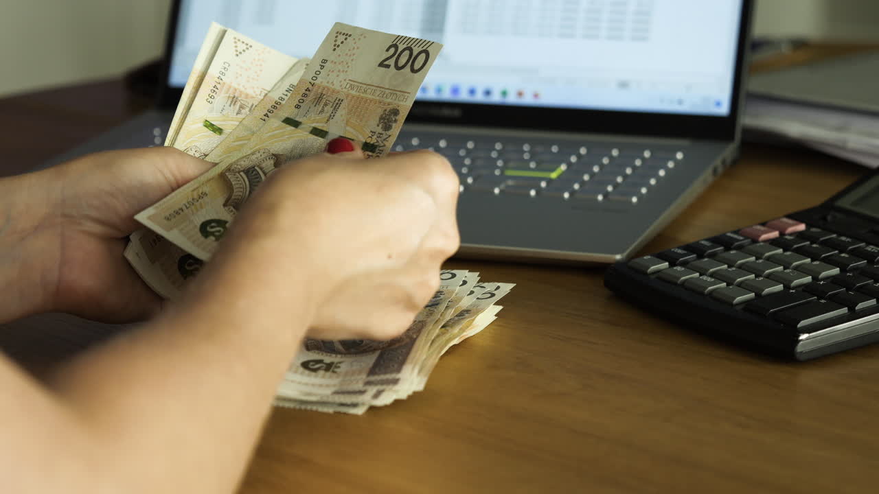มือผู้หญิงกำลังนับธนบัตร 200 ซลอตีโปแลนด์บนโต๊ะ - แนวคิดธุรกิจ, การเงิน, ไลฟ์สไตล์, งบประมาณครัวเรือน, ภาพมุมกว้าง