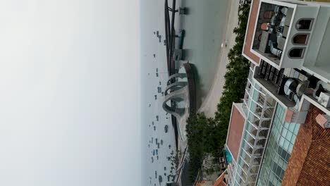 vertical - clock tower (thap dong ho) and kiss of the sea show venue in sunset town, phu quoc, vietnam. aerial panning reveal