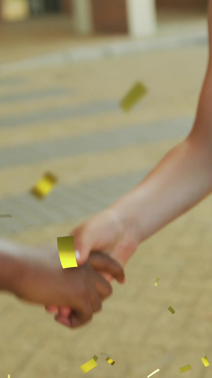 Animazione di coriandoli dorati su allegri studenti di diverse etnie con diploma e tocco che si stringono la mano