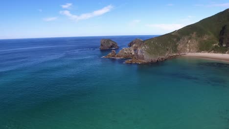 Aerial,-tilt-down,-panning-shot-Torimbia-beach-horizon,-Llanes,-Asturias,-Spain