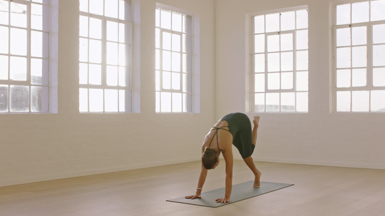 linda mulher de ioga praticando pose de divisão de cachorro voltada para baixo, desfrutando de estilo de vida fitness, exercitando-se em estúdio, alongando o treinamento corporal flexível, meditação matinal no tapete de exercícios