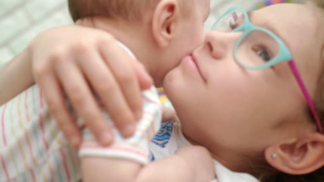 Precioso-Bebé-En-Abrazo-De-Hermana.-Cerca-De-Una-Niña-Feliz-Abrazando-A-Su-Hermano-Menor