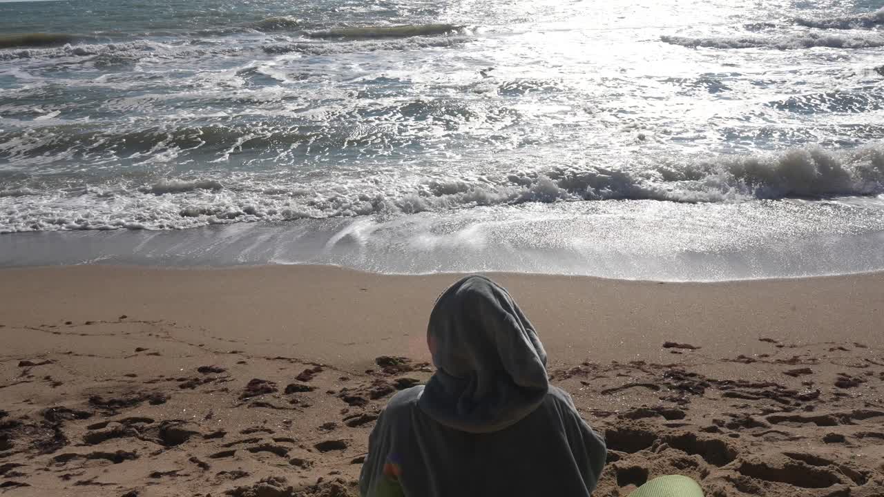 해변 에 앉아 바다의 파도 를 상 하는 사람
