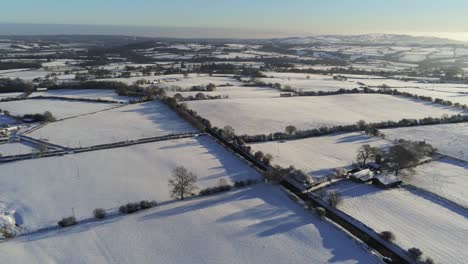 Frío-Invierno-Nevado-Británico-Mosaico-Tierras-De-Cultivo-Campo-Rural-Escena-Aérea-Al-Amanecer-Cinemática-Izquierda-órbita