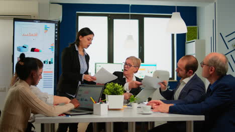 secretary bringing coffee and meeting documents while team planning financial strategy