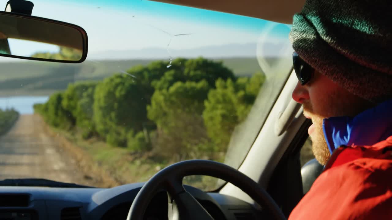 Uomo alla guida di un'auto in campagna 4k
